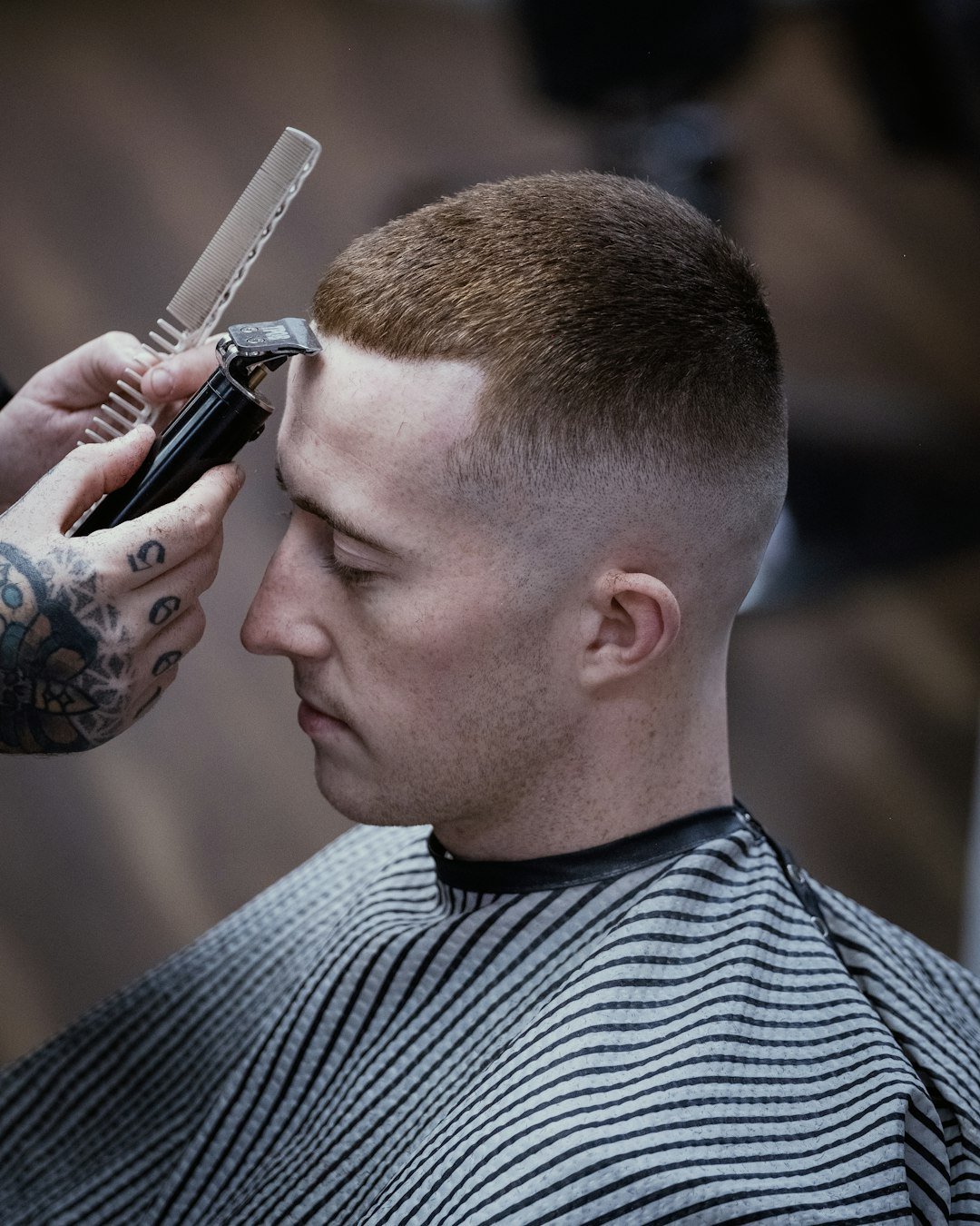 about-us-02 a-man-getting-his-hair-cut-by-a-barber-xo8opsasyza